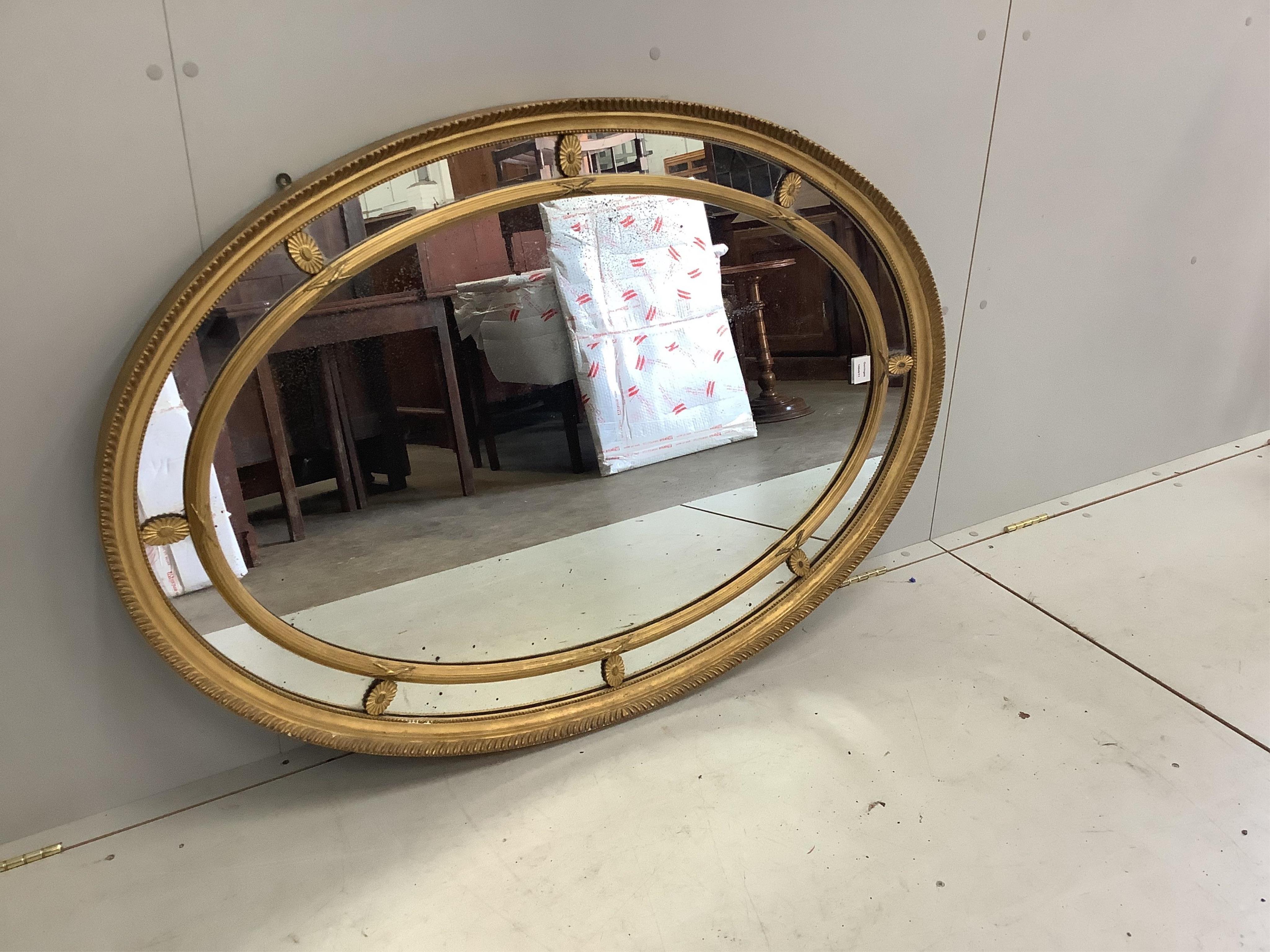 A Sheraton style oval marginal plate wall mirror, width 85cm, height 124cm. Condition - good